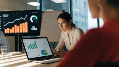 Gestora analisando um painel de métricas empresariais em um notebook, com gráficos de receita, conversão e satisfação do cliente em uma reunião de negócios.